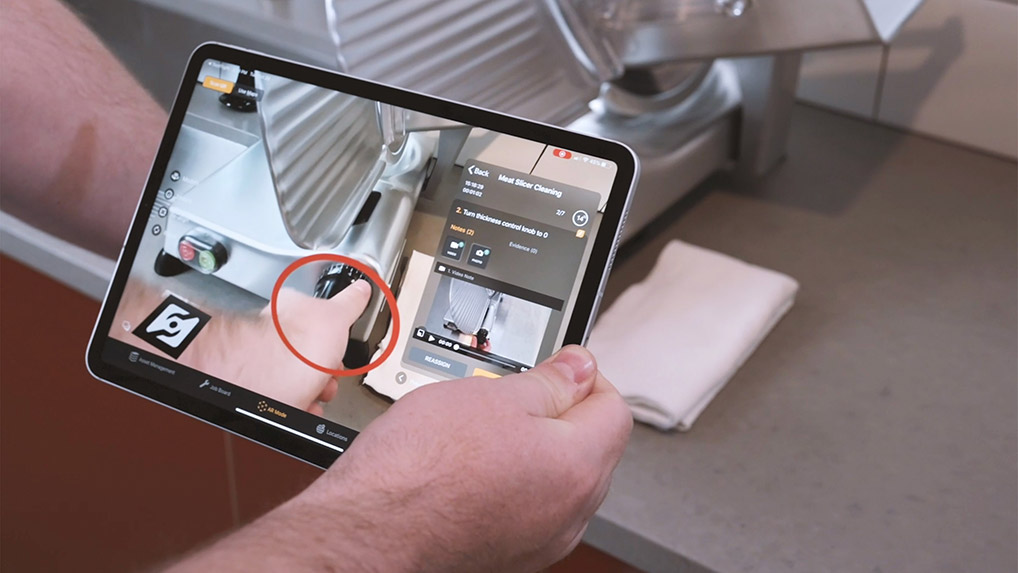 person holding an ipad with augmented work instructions on it