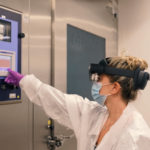woman in white coat performing task with an ar headset