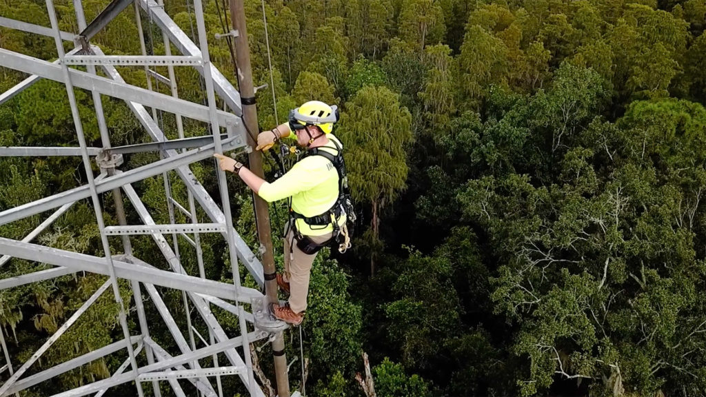 telecom worker using augmented goggles while working on cell tower
