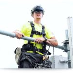 telecom worker in harness and wearing an augmented reality headset