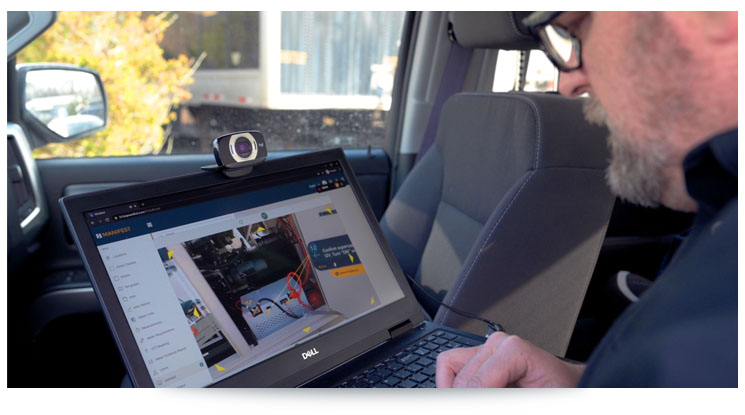 man sitting in a car using a laptop with digital instructions