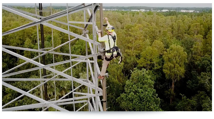 telecom worker climbing a cell tower