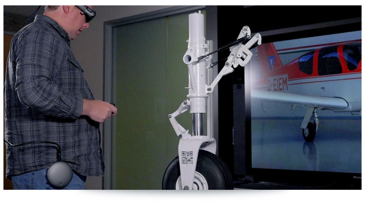 man inspecting plane landing gear while wearing augmented reality headset