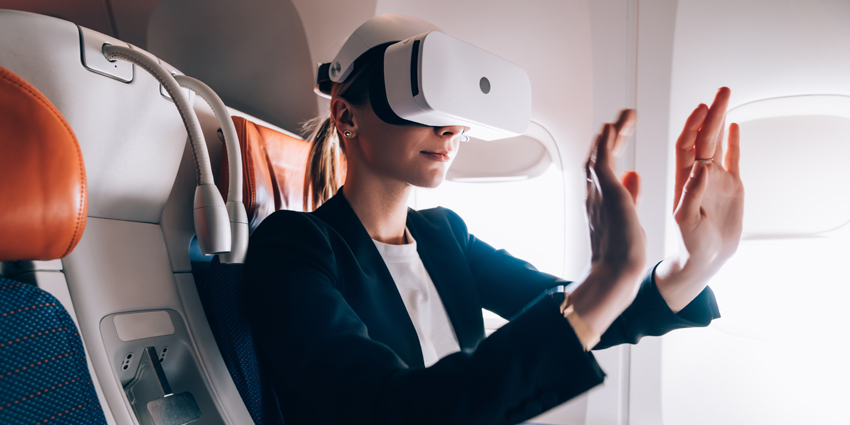 woman in plane seat wearing ar headset with her hands up
